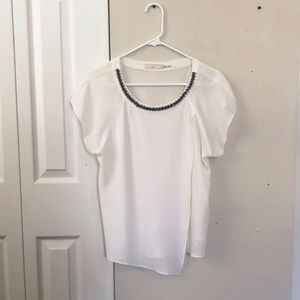 White blouse with black beaded detail collar